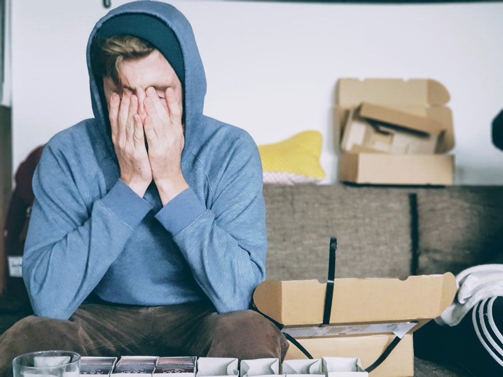 Stressed man in room with open boxes.