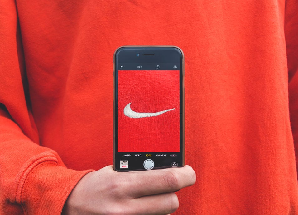 man holding phone with nike logo
